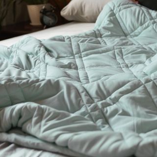 Blue cooling weighted blanket on bed
