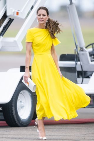 Kate Middleton carries a white clutch as she arrives at Norman Manley International Airport as part of the Royal tour of the Caribbean on March 22, 2022 in Kingston, Jamaica.