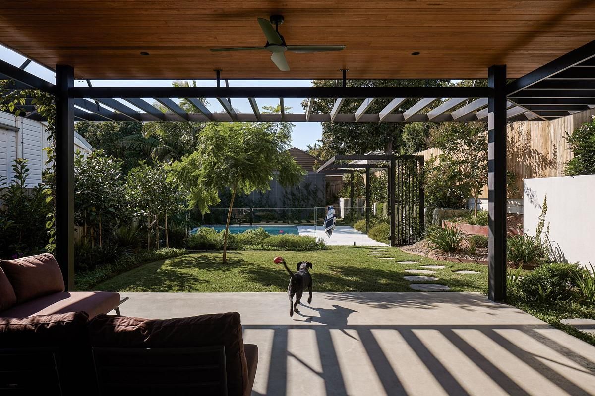covered area in Australian backyard with swimming pool, lawn, and dog
