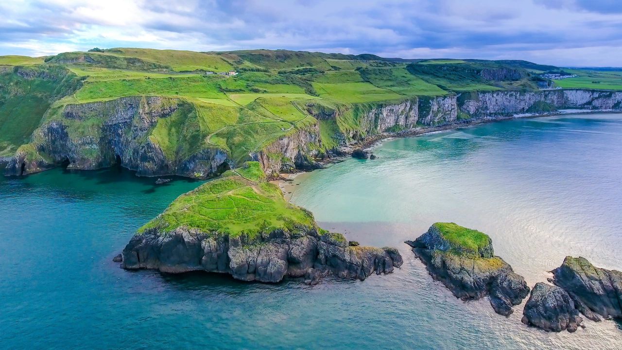 The aerial view of the two islands in Carrick-a-Rede with the rope bridge connecting the two islands in Ireland