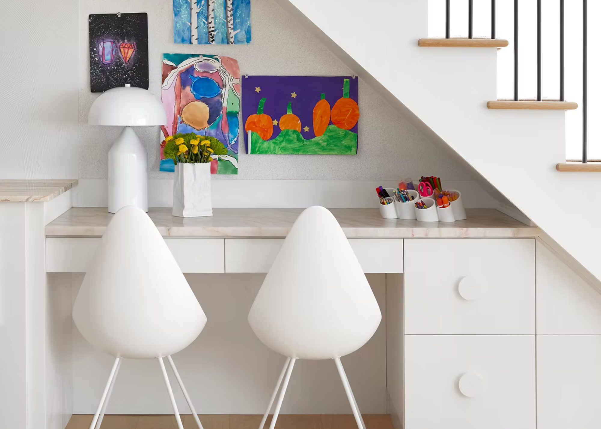 under the stairs storage with built-in desk and artwork on the wall with two chairs and a table lamp