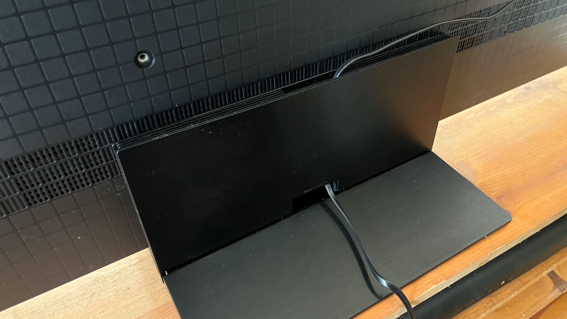 TCL QM7K pedestal stand showing cable management