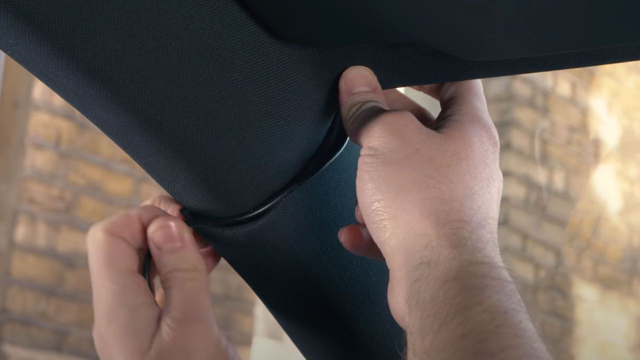 Some hands installing the a dash cam cable inside a car