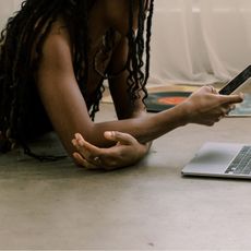 A woman lying on the floor scrolling on her phone