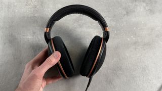 The Sennheiser HD 505 headphones held in a man's hand