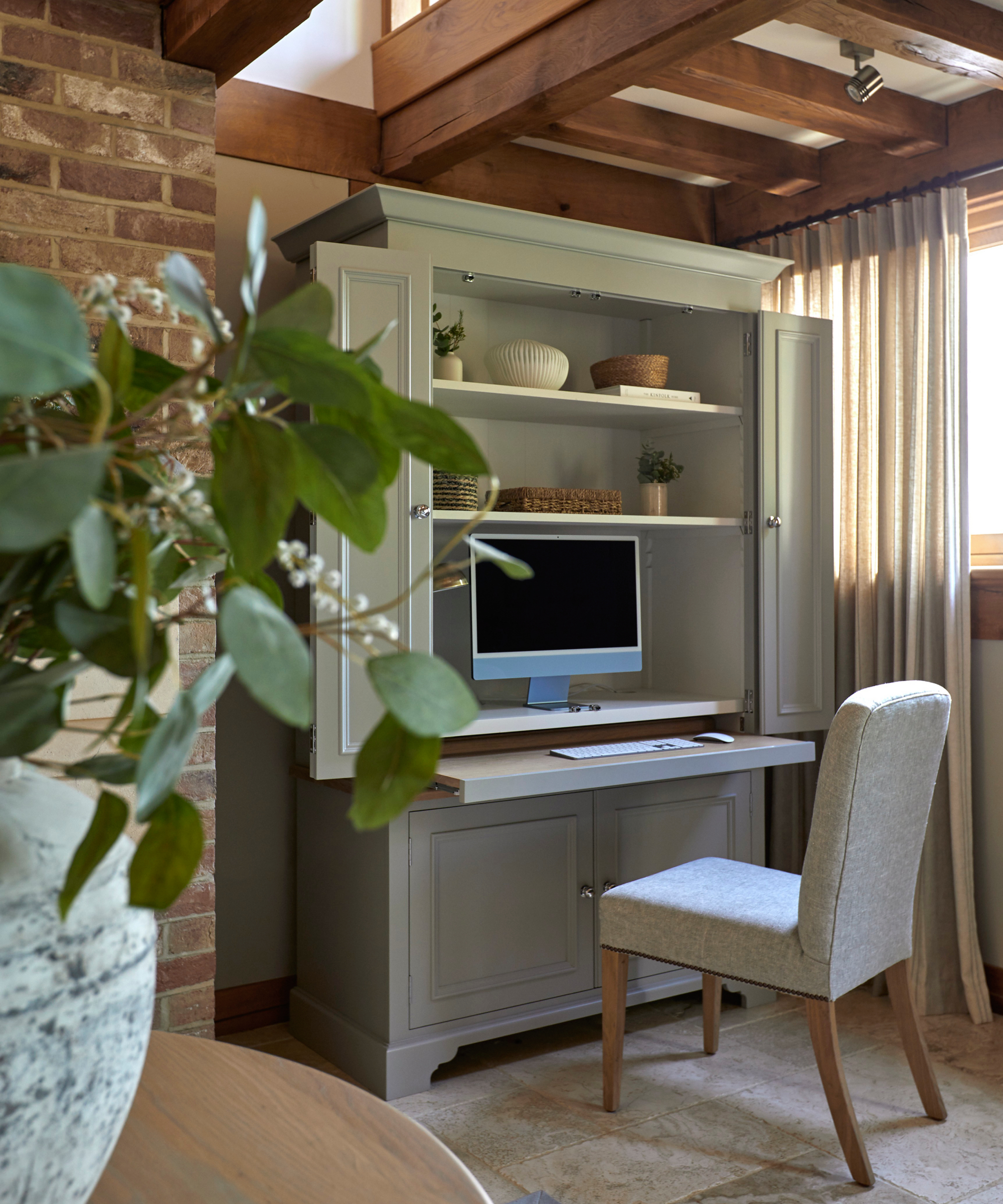 taupe coloured office bureau with doors open and cream desk chair in front of pull out desk