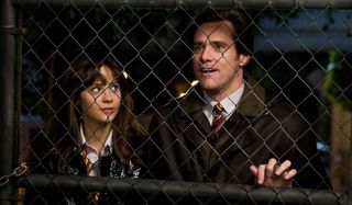 Zooey Deschanel and Jim Carrey stand behind an iron fence in Yes Man.