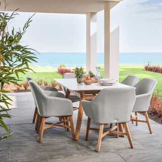 patio cover on floor tiles with modern table and chairs, view of the sea