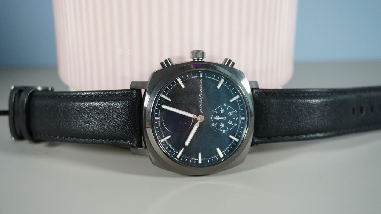 The Pininfarina Senso Hybrid smartwatch on a grey background against a pink plant pot