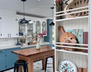 Kitchen with blue cabinets, wooden table, and barstool