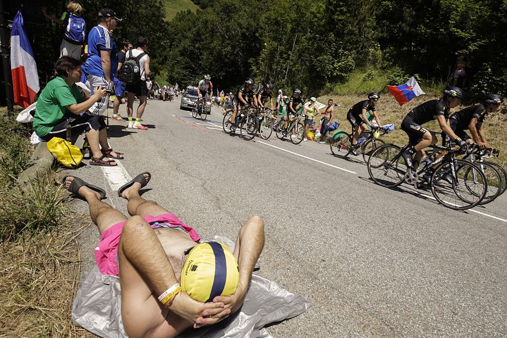Fans relaxing at the side of the road as they watch the peloton fly by