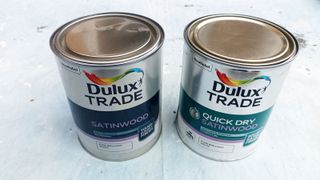 Two Dulux Trade tins of paint side by side