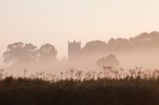 Tamworth church tower in the mist on the Norfolk broads, Norfolk.