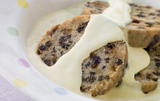 A bowl of spotted dick with custard