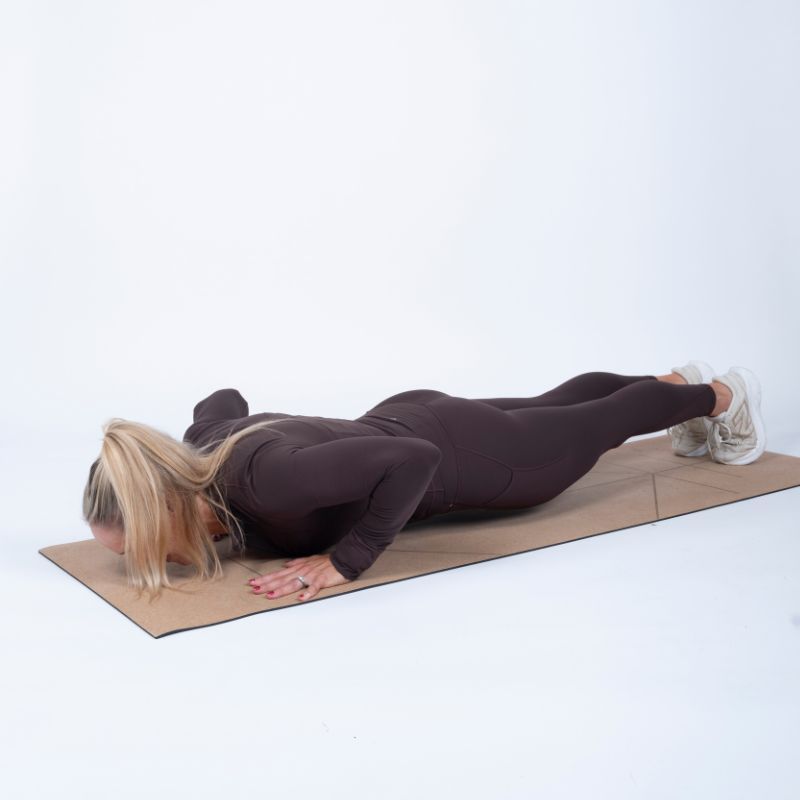 Sarah Campus doing negative push up on yoga mat in the bottom position