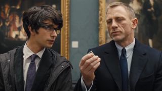 Ben Whishaw talks while Daniel Craig inspects his mini-radio transmitter in Skyfall.