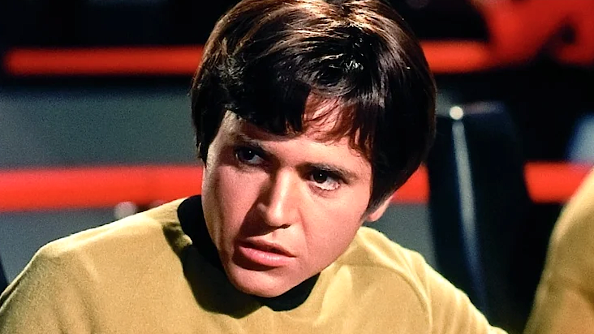 a young man in a gold uniform from a sci-fi show