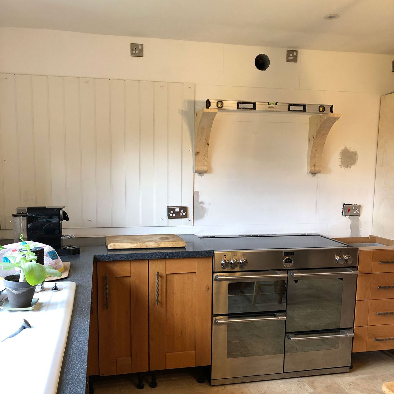 Wooden kitchen with upper cabinets ripped out and white walls