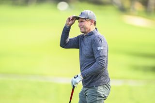 Steve Young touches his cap as he walks off the green