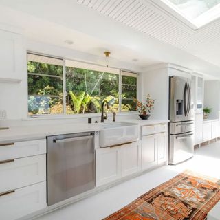 kitchen with white painted walls and orange rug on floor