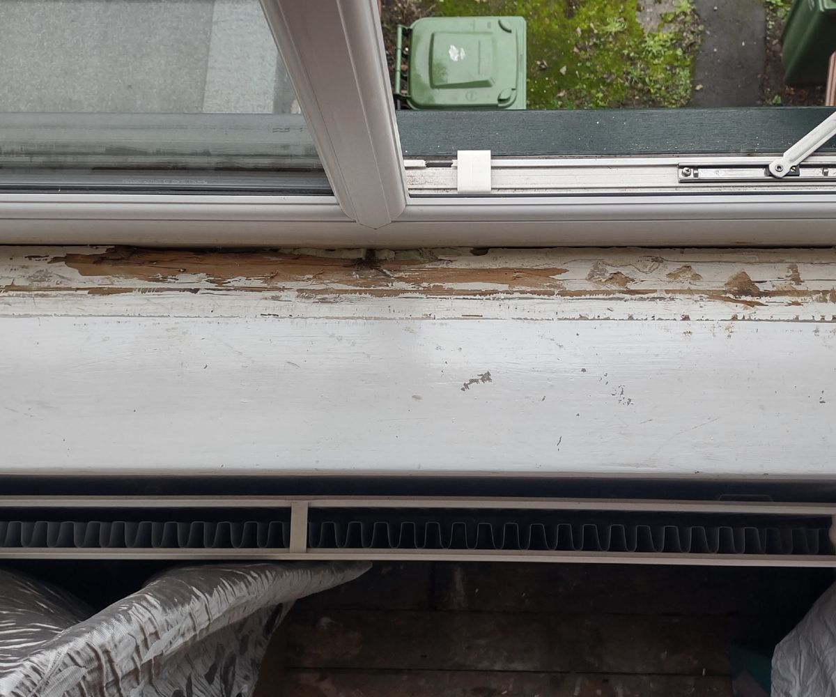 A windowsill with thick white chippy paint