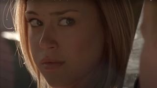 Adrianne Palicki sits in a car looking upset in Friday Night Lights.