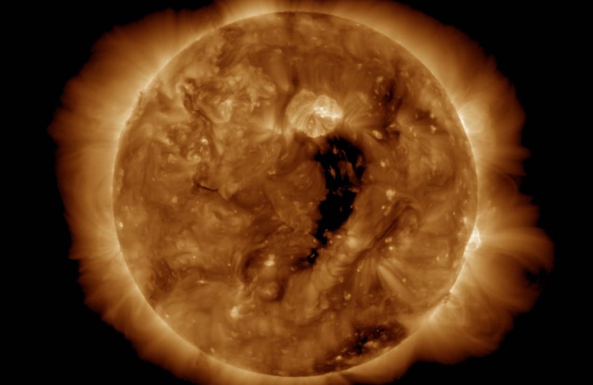 The canyon-like hole, visible as a dark gulf running vertically down the sun&#039;s center.