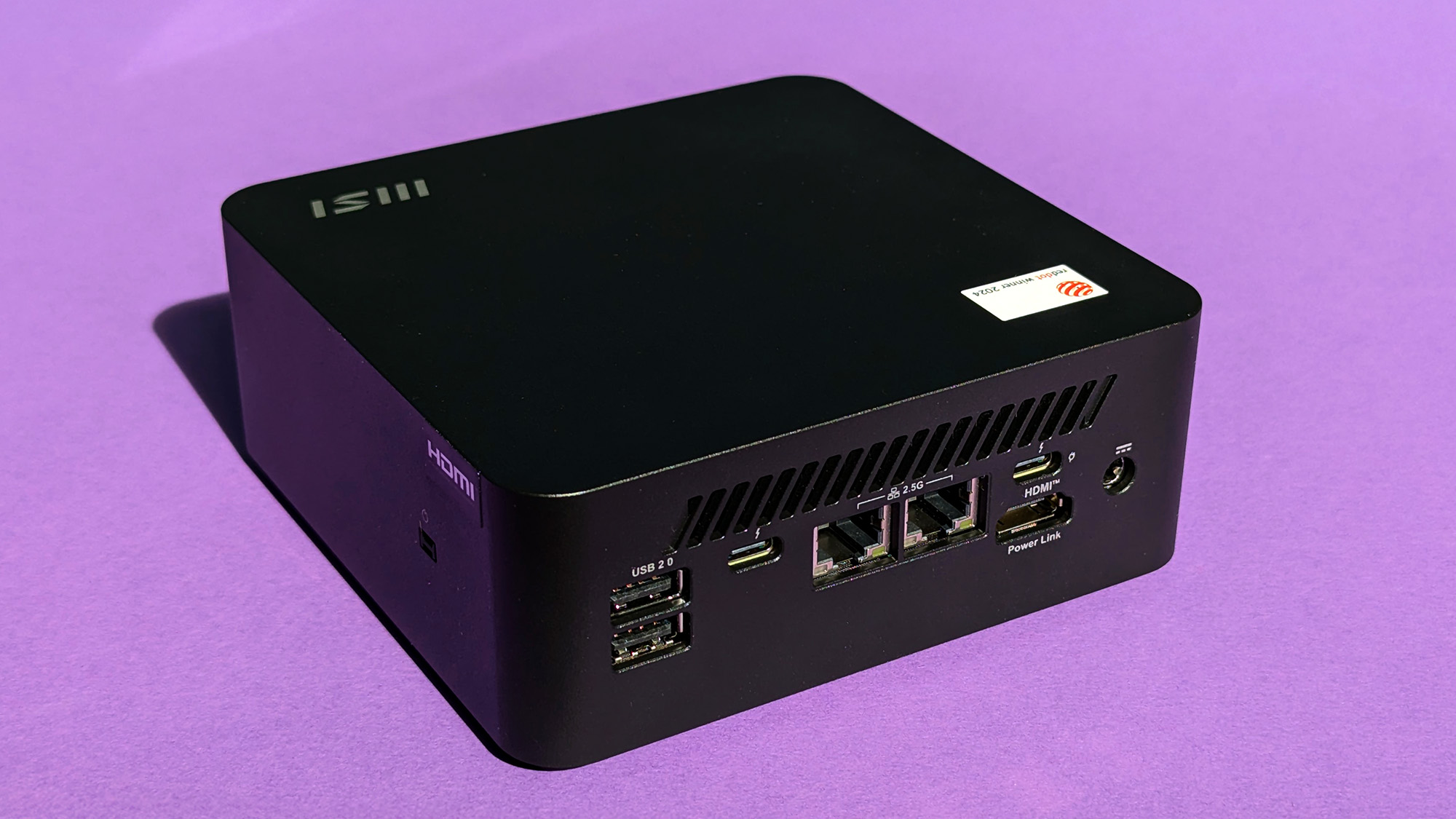 MSI Cubi NUC AI+ 2MG mini PC on a purple card stock background