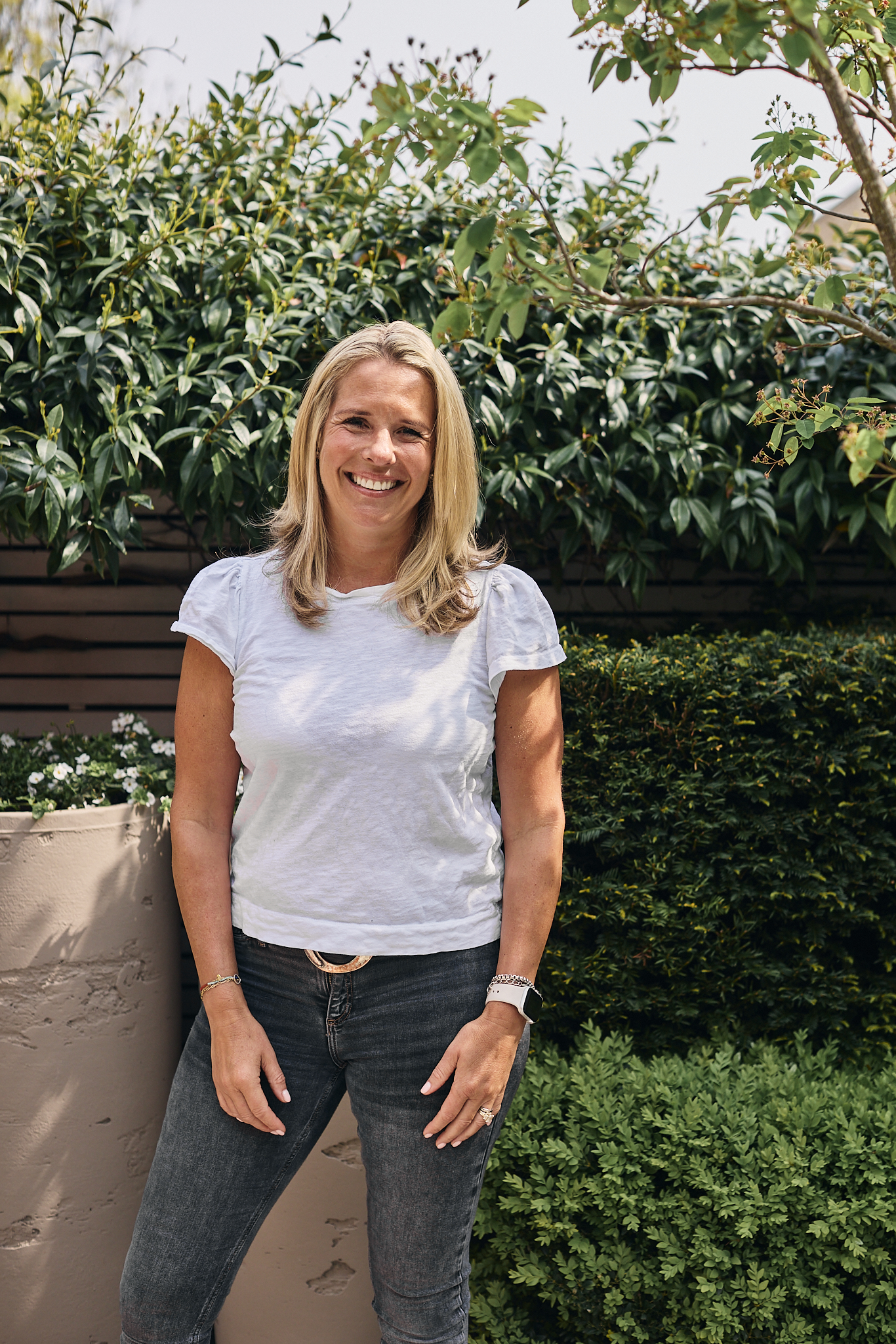 woman with blonde hair wearing black jeans and a white t-shirt