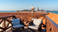 Armchairs on wooden altana, or roof terrace, at Venice hotel Ca’ di Dio, with view