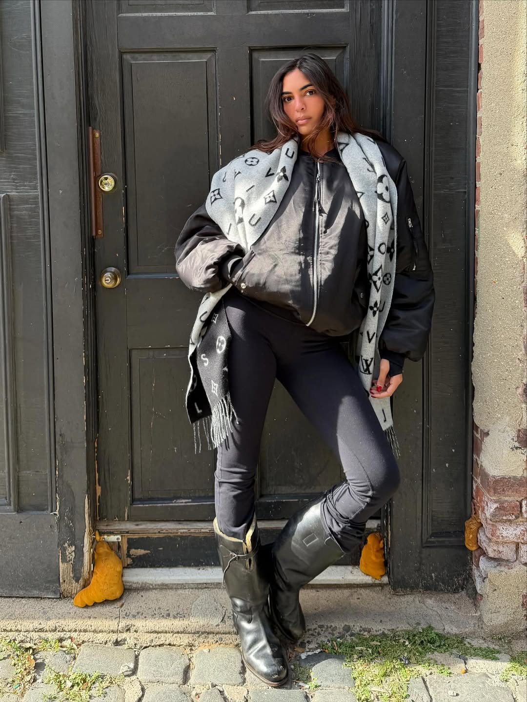 Sandra Shehab wears a oversized bomber jacket, leggings and shearling lined boots.