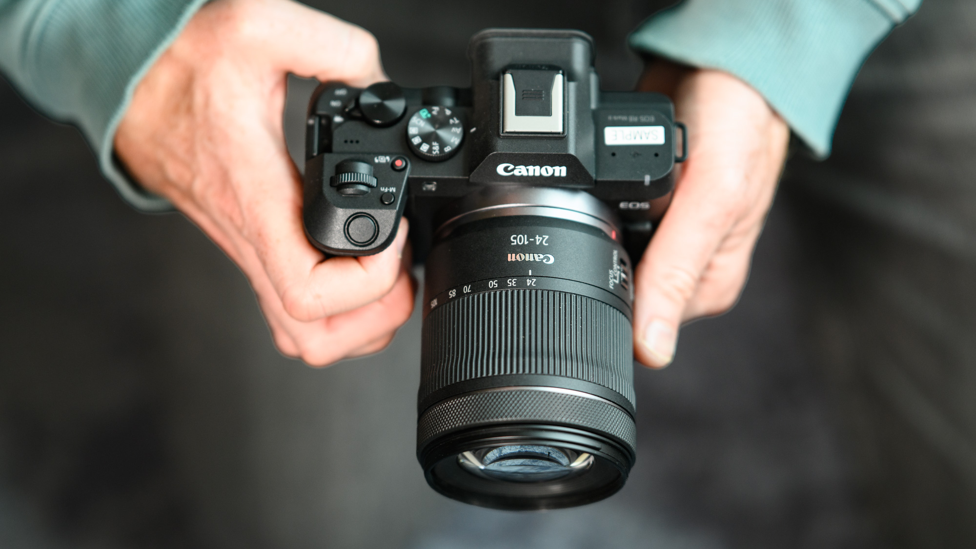 Top of the Canon EOS R8 Mark II, in user's hands, 24-105mm lens attached