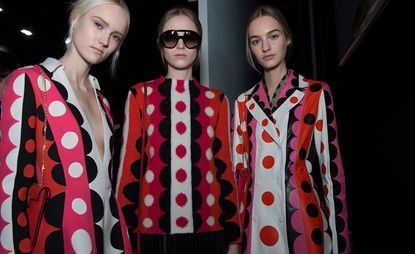 Three models wearing outfits in white, red and pink spots and half-circles