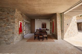 ridge house dining space wrapped in stone walls
