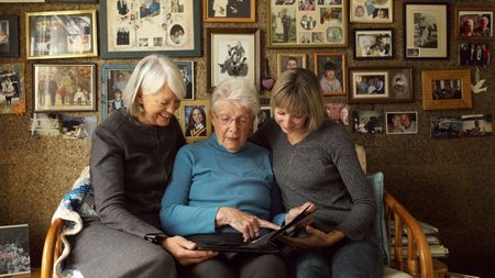 Three generations of women looking at photo album