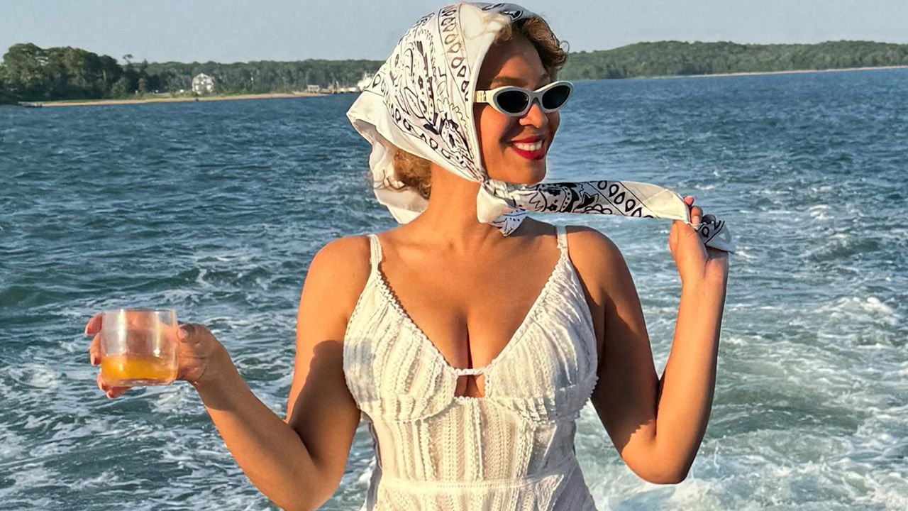 Beyonce on a yacht in the Hamptons wearing a white on sale sundress and a white bandana