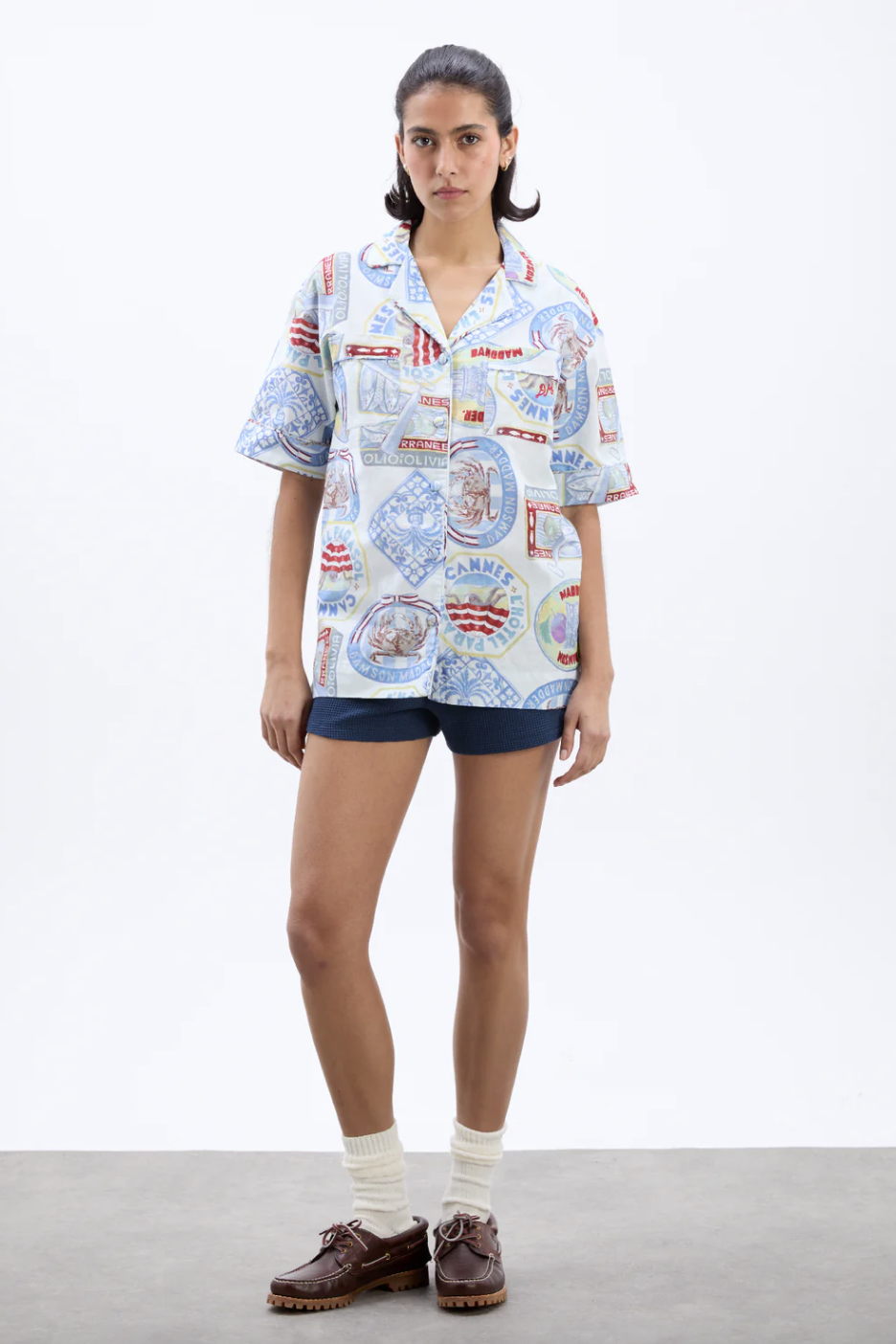 a model wearing a damson madder shirt with shorts in front of a plain backdrop