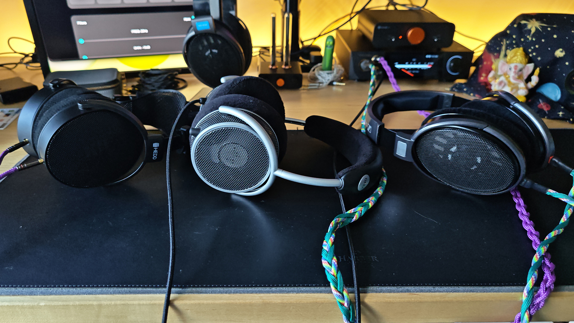 Three headphones sat on a desktop.