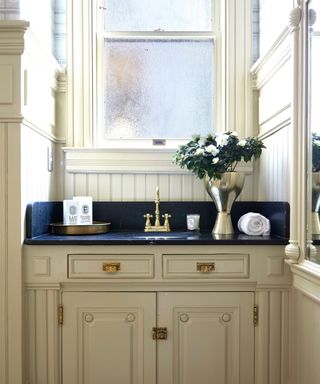 bathroom vanity with antique molding and gilded art deco hardware