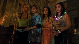 Bee, Sophie, Emma, and Alice wear bloodied clothes as they stare at something off screen in Bodies Bodies Bodies