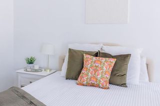 White bedroom with green cushion