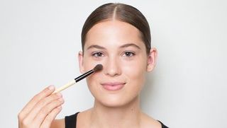 woman blending out foundation on her face