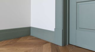 Painted baseboard and door in sage green