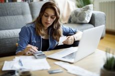 Woman using calculator and looking at finances
