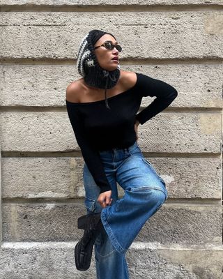 woman wearing flare jeans and black off the shoulder top