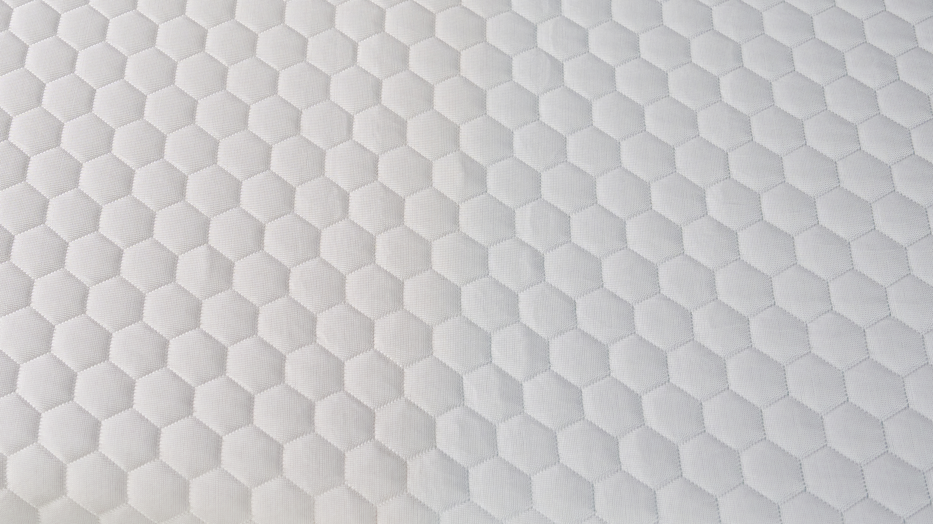 The hexagon-patterned pattern of the cooling GlacioTex cover of the Helix Dual Comfort Mattress Topper.