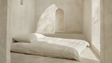 Bedroom with limewash walls and a bed without a frame
