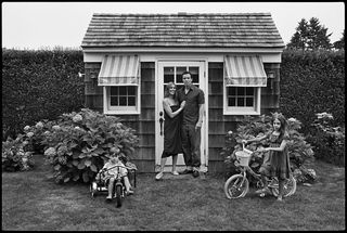 photograph of family outside small house