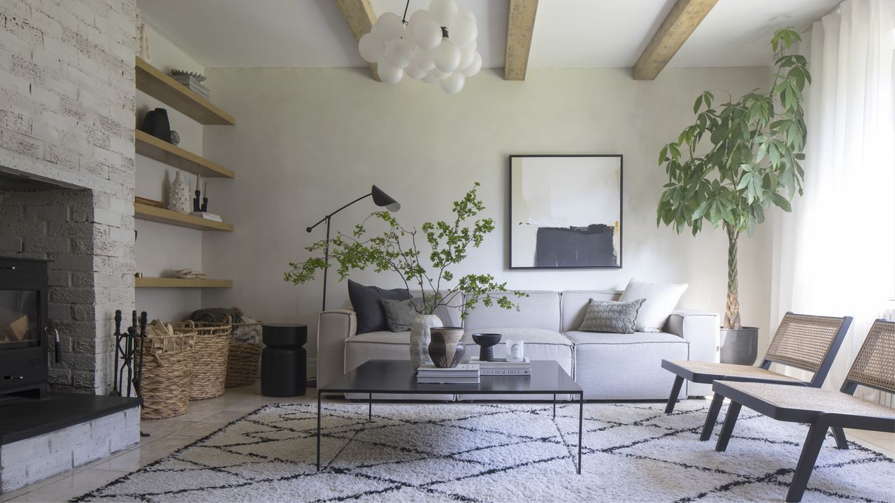 A white living room with faux wood beams and minimalist furniture