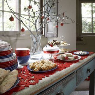 Wooden console with plates, Christmas decorations and treats